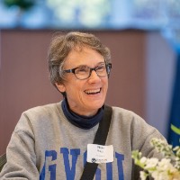 Diane Houge smiling while holding a mug handle